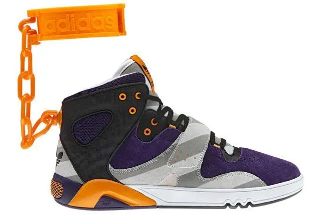 A white high-top sneaker with orange and yellow accents, featuring a controversial design with orange plastic shackles attached to the ankle.