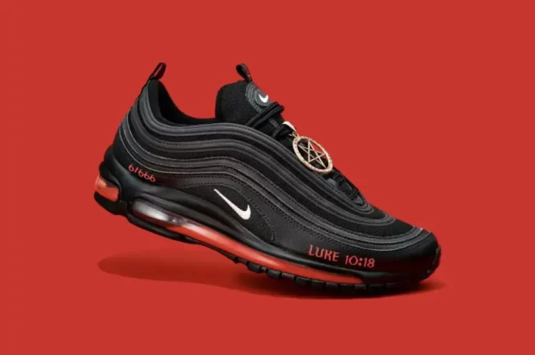A black and red low-top sneaker with satanic symbols and references on the sole, created in collaboration with musician Lil Nas X and containing a drop of human blood. Let's Start alt text for the back side of nike air bakin Alt text for the back side of Nike Air Bakin: The back of the shoe features a black heel with a large Nike logo and a red stripe running down the center. The ankle collar is padded and black, with a white Nike Air logo on the back. The midsole is white with black and red accents, and the outsole is black with a red Nike logo.
