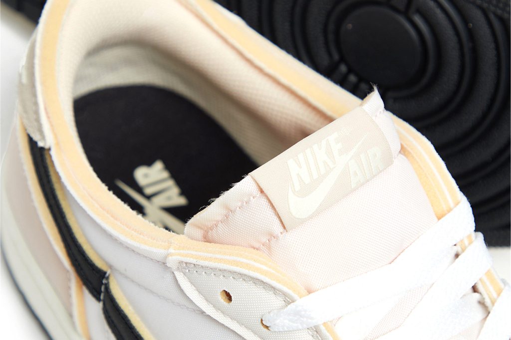 Front side close-up of Air Jordan 1 Low 'Coconut Milk' sneakers featuring neutral-toned design and enhanced water resistance.