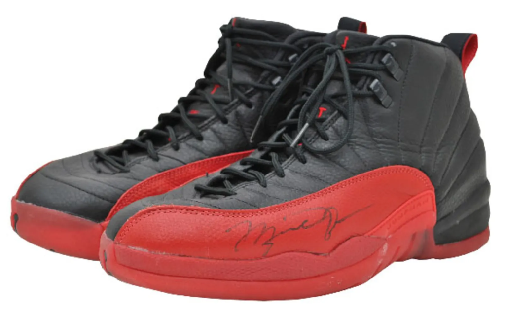 Notable Air Jordan 12 "Flu Game" sneakers worn by Michael Jordan during a historic game, embodying resilience and iconic black and red colorway.