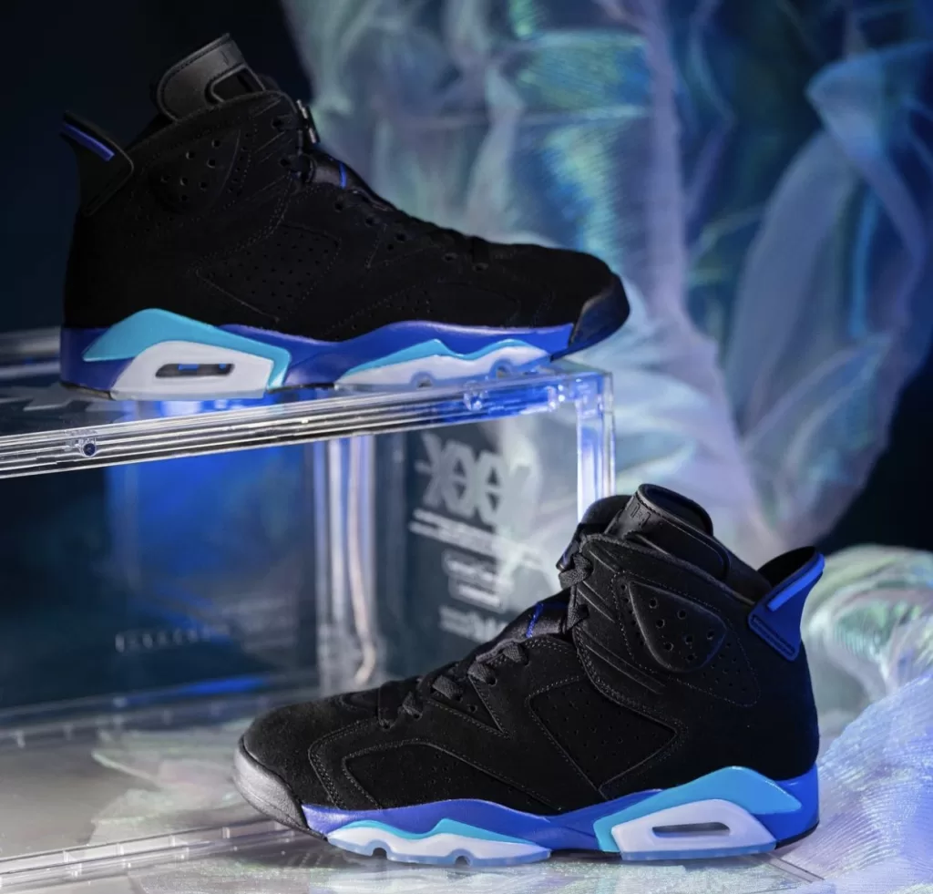Image displaying the Air Jordan 6 "Aqua" sneakers in a Black, Bright Concord, and Aquatone color scheme, featuring a sleek design with a Black nubuck upper and contrasting accents, resting on an icy translucent outsole.